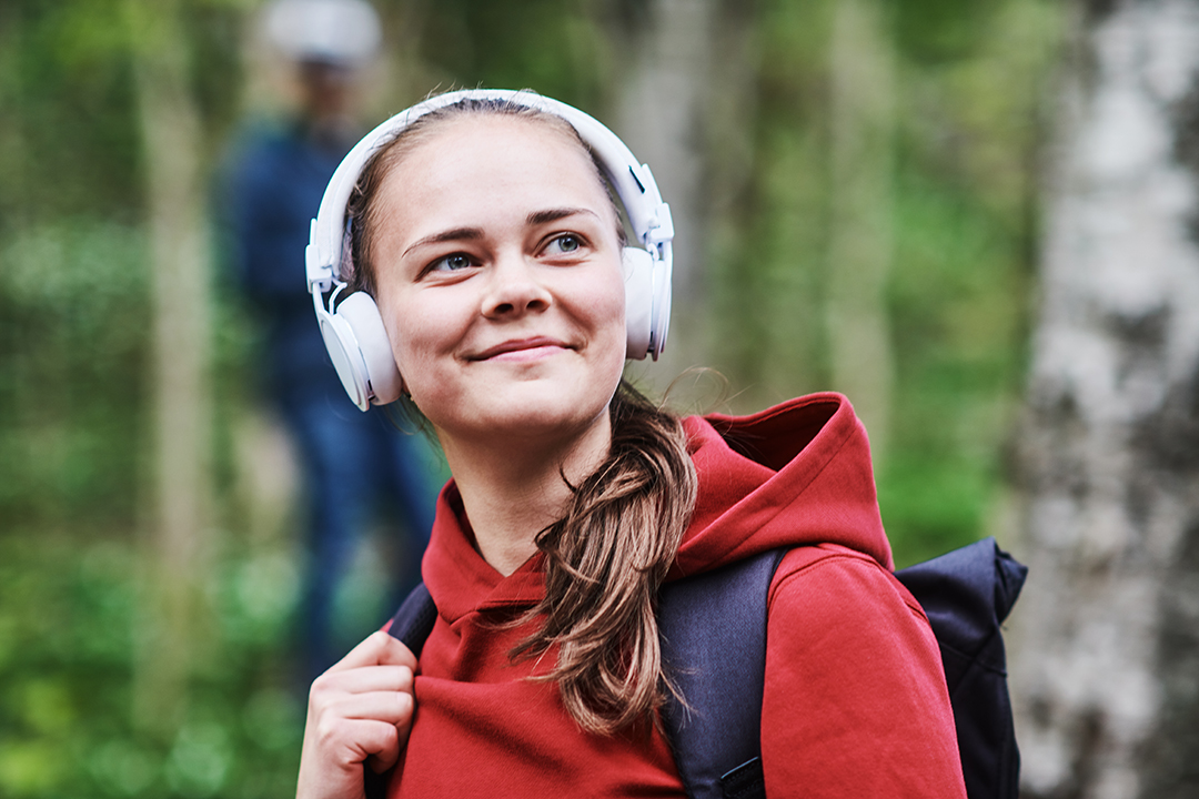 Jente med hodetelefoner lytter til lydbok.
